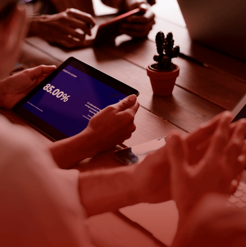Cropped hands of team members using tablet computer and laptop in meeting