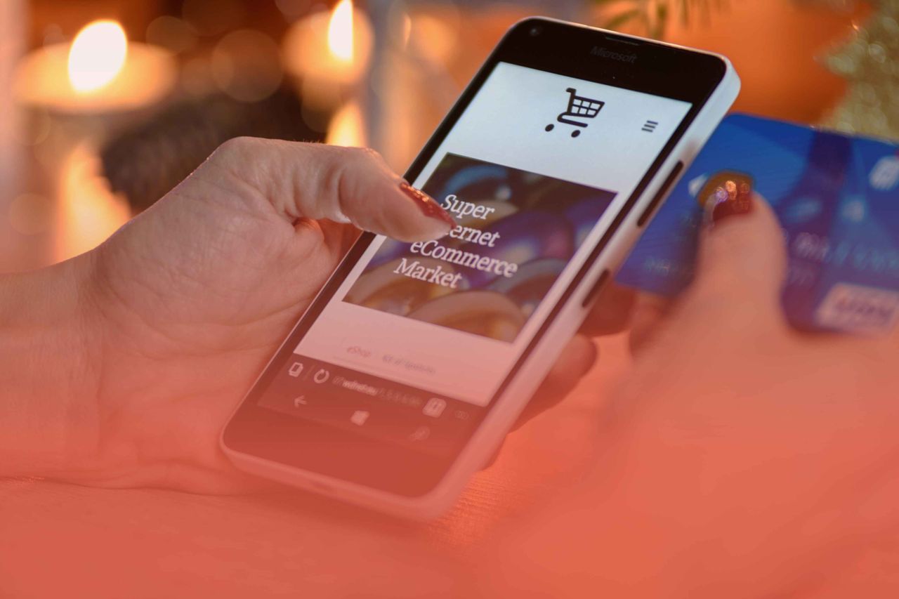 Person using a smartphone with a credit card nearby