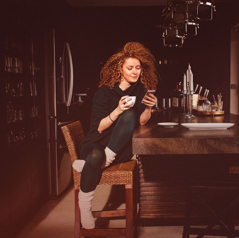 Woman scrolling a phone and drinking tea_image