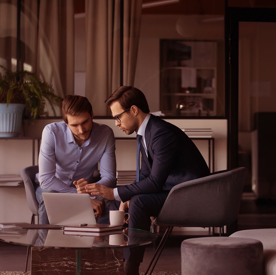 Two men discuss business in a modern office_image