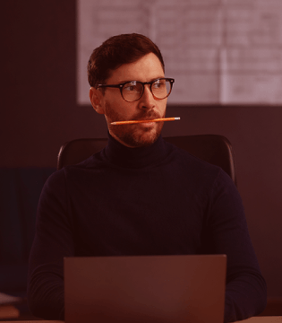 Man thinking with pen in mouth at work_image