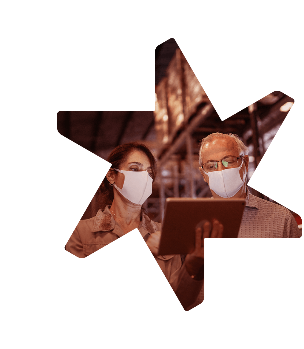 Tandemite banner: 2 manufacturers in a mask looking at the tablet in a warehouse