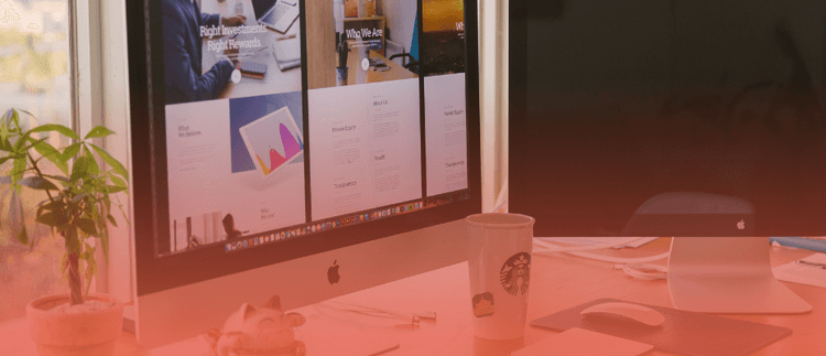 Modern workspace with Apple iMac computers displaying a website editing interface, illustrating a visual content editing experience similar to Storyblok Visual Editor