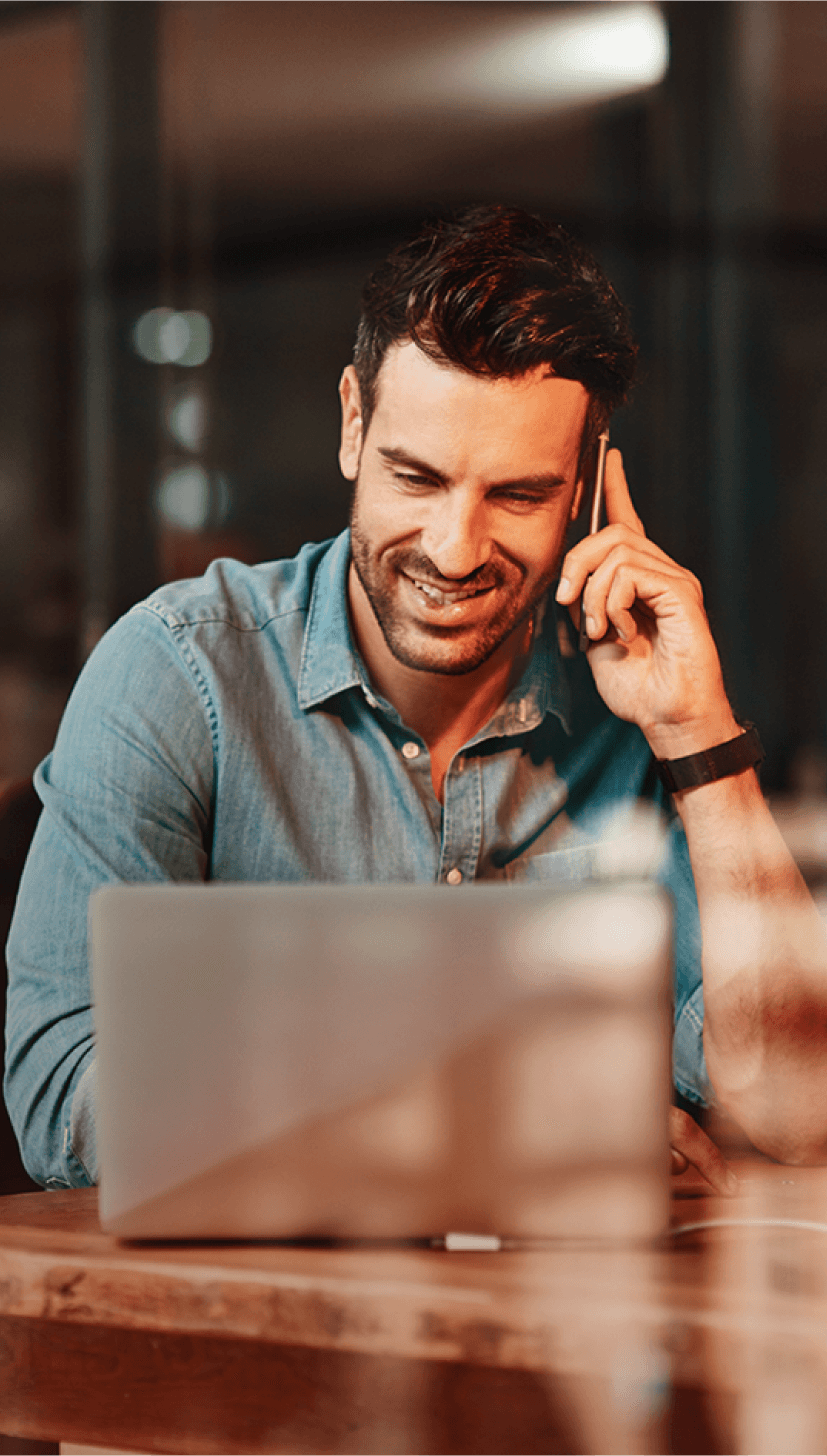 Male working on a laptop and making a call_image